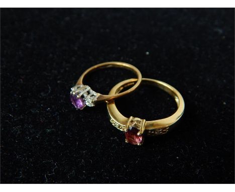 Two 9 ct yellow gold, gem-set rings, one set with a central, oval, faceted ruby flanked by a small diamond to each shoulder (