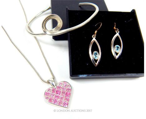 A collection of silver jewellery including a bangle, a pair of earrings and a necklace.