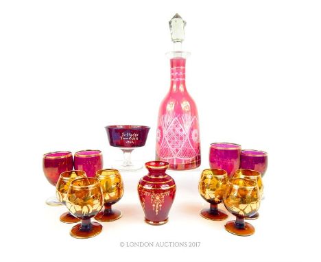 A collection of 13 ruby and amber glass wares including a decanter.