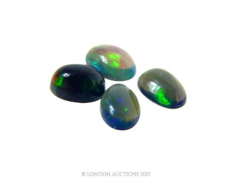 Four loose, fire opal, cabochon stones in dark shades of black, purple, green and blues. Good 'fire' to each individual stone