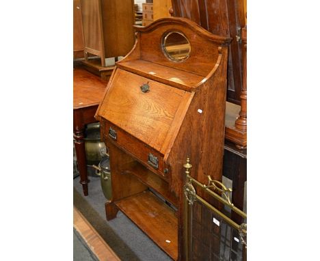 Edwardian oak secretaire, shaped back with a mirror, fall front enclosing a part fitted interior, single drawer and open shel