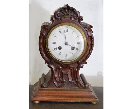Victorian carved walnut mantel clock, white enamelled dial, cylinder movement, striking on a gong, (lacking pendulum), 30cms.