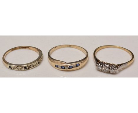 Yellow  metal three-stone diamond ring, two diamond and sapphire eternity rings, (3).