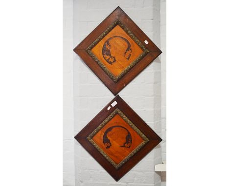 Pair of Arts & Crafts lozenge-shaped wall plaques, poker-work decoration, with portrait heads, gilt composition slips in wood