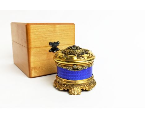 A FABERGE SILVER GILT AND BLUE ENAMELLED CIRCULAR BOX, embossed lid set with ruby and diamonds, with a diamond lid stud of ap