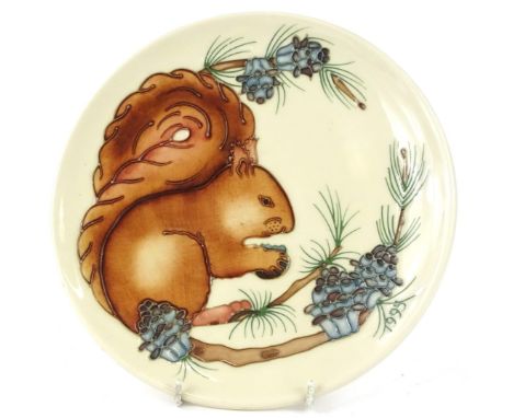 A Moorcroft 1995 year plate, decorated with a squirrel and foliage on a cream ground, designed by Rachel Bishop, tube lined b
