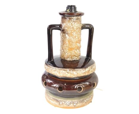 A German Fat Lava two handled lamp base, decorated with brown glaze and a tapering shade, the base 47cm H.