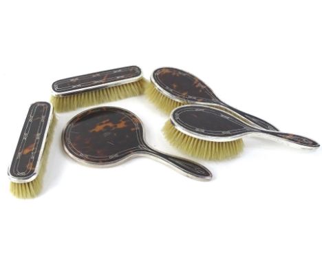 A George V tortoiseshell shell and silver pique part dressing table set, to include brushes and a hand mirror, Birmingham 192