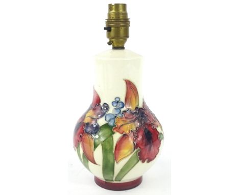 A Moorcroft Orchid pattern lamp base, decorated with flowers and leaves on a white ground, designed by William Moorcroft, imp