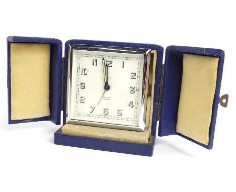 A Smiths seven jewel alarm clock, in chrome plated case with outer blue travelling case, 9cm W.