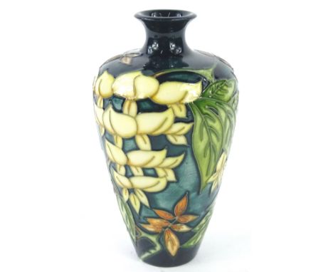 A Moorcroft Wisteria pattern vase, decorated with flowers and leaves etc., on a mottled green ground, designed by Philip Gibs