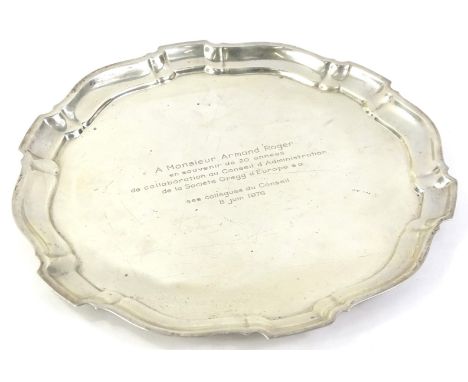 A Continental white metal salver, with pie crust border, engraved "Monsieur Armand Roger etc", dated 1976, stamped to undersi