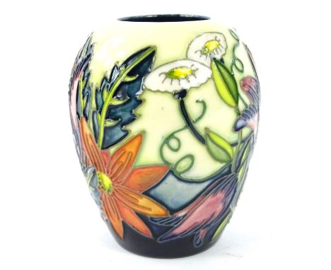 A Moorcroft Castle Garden pattern vase, decorated with flowers, leaves, etc. on a light green and blue ground, designed by De