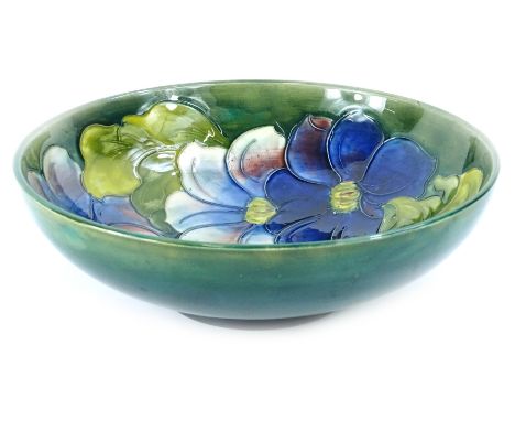 A Moorcroft Clematis pattern bowl, decorated with flowers, on a green ground, impressed mark and initials to underside, also 