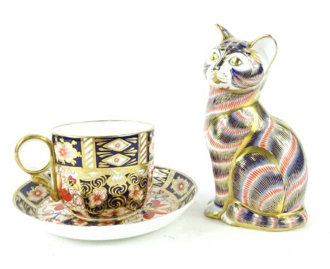 A Royal Crown Derby Imari porcelain cat, with gold button, and a Royal Crown Derby Imari pattern cup and saucer. (3)