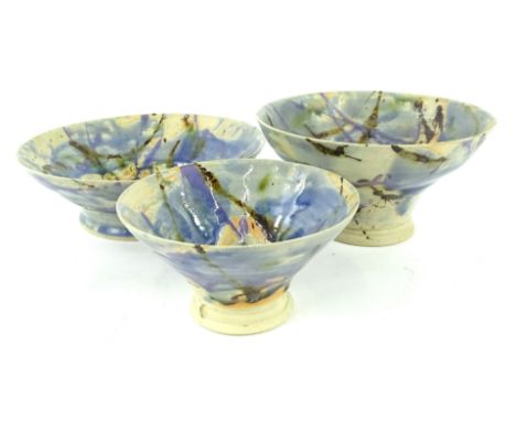 A graduated set of three studio pottery bowls, each with a purple blue and green mottled glaze, marked to centre, incised and