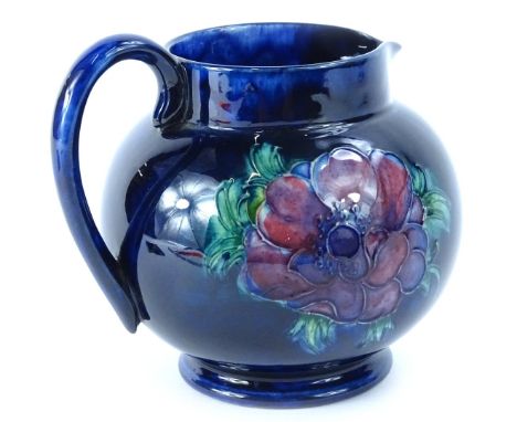A Walter Moorcroft Anenome pattern pottery jug, on a cobalt blue ground, impressed mark to underside, stamped Made in England
