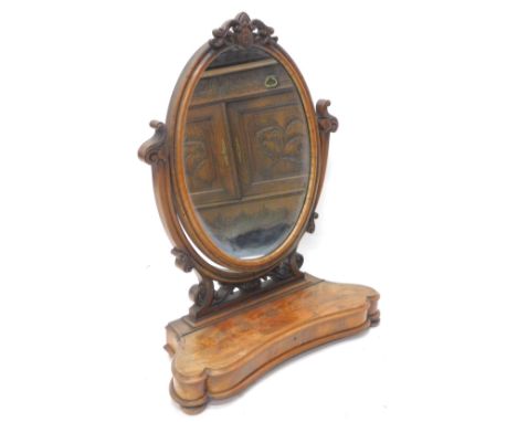 A Victorian figured mahogany dressing table mirror, with oval plate on shaped pierced supports, the base with a moulded edge,