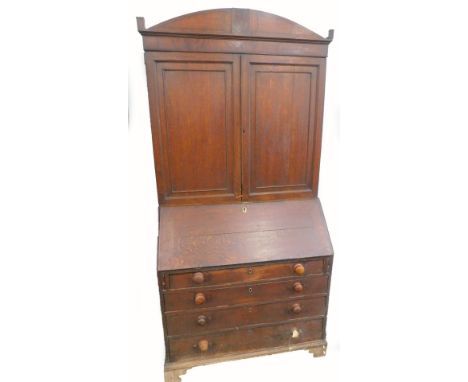An early 19thC oak and mahogany cross banded bureau bookcase, the top with two panelled doors enclosing shelves, the base wit