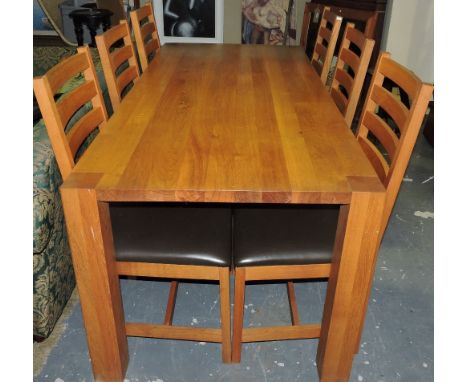 A Heals retailed contemporary rectangular oak dining table together with six matching ladder back chairs with brown leather s