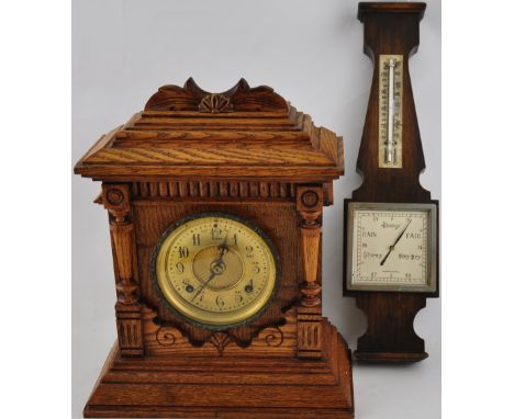 An early 20th Century American oak cased 8 day chiming clock together with a barometer of similar vintage 