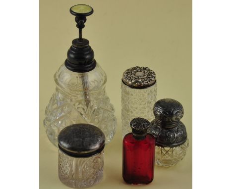 Four Victorian/ Edwardian silver mounted perfume bottles and toilet jars together with a yellow enamel silver mounted cut gla