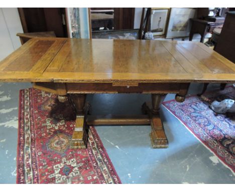 A 1920's oak extending dining table, on ornately-carved base