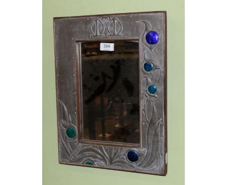 A pewter and enamel mirror with foliate decoration and monogram 