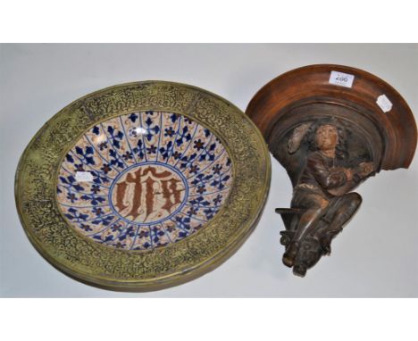 A late 19th/early 20th century Continental carved wall bracket; together with a brass mounted circular Hispano-Moresque plate