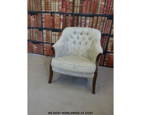 A mahogany button backed upholstered chair with floral material 