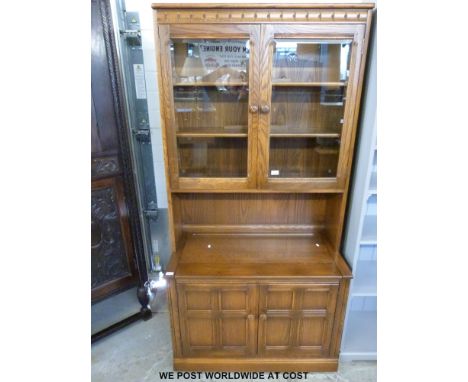 An Ercol dresser with glazed display cabinet to top, lift up flap and cupboard to base (W98 x D50 x H197cm) 