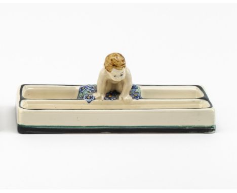 Grauer Scherben. Beiger Fond. Rechteckiger Sockel, unterteilte  Fächer mit kniendem Putto auf Blütendekor. Polychrome Bemalun
