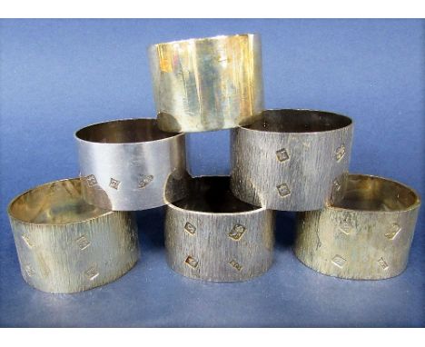 Set of five boxed napkin rings with textured finish, maker SJR, London, 1972/73, each 2.1 oz approx; together with a further 