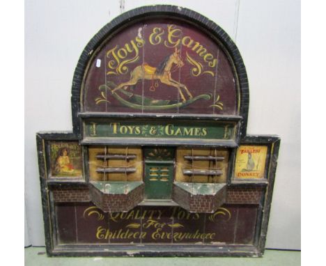 A painted vintage wooden wall mounted sign board of rectangular stepped arched form with toy shop frontage advertising toys a