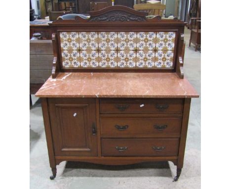 A late Victorian/Edwardian walnut washstand with coloured marble top and raised tiled splashback over three drawers and a cup