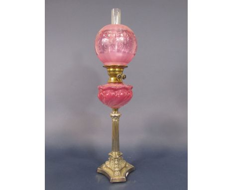 A Victorian oil lamp with silver plated column, supporting an embossed pink glass font, further brass fittings and globular s