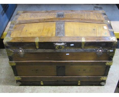 A substantial Victorian travelling trunk with arched lid, steel banded and further brass strap work
