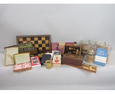 A 19th century mahogany travelling chess/droughts board containing a collection of draughts, further vintage games, together 
