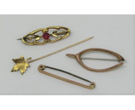 Group of gold items comprising a stick pin in the form of a maple leaf, stamped 10k, together with three antique 9ct brooches