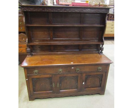 A good quality Edwardian oak dresser, the base enclosed by three rectangular panelled and arched moulded doors and two drawer