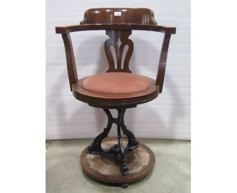A vintage ships chair, the bowed back with pierced splat over a circular upholstered pad seat, raised on cast iron supports a