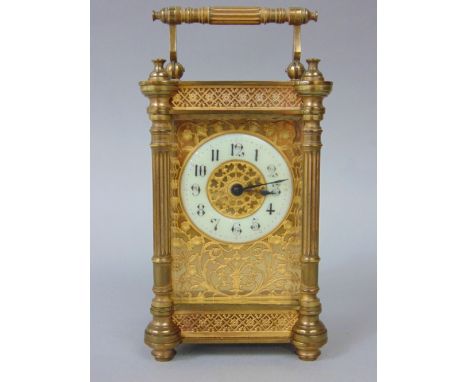 A brass architectural cased carriage clock with gilt fretwork dial and enamelled chapter ring with Arabic numerals, 13 cm hig