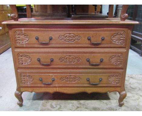 A medium to light oak commode of three long drawers with carved acanthus detail and short scrolled cabriole supports, 106 cm 