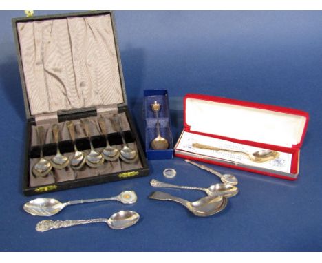 A collection of various silver spoons to include a caddy spoon, set of six silver teaspoons, souvenir spoons, etc