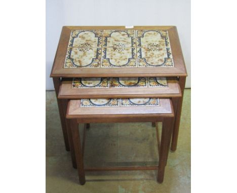 A nest of three graduated Danish teak occasional tables with inset glazed ceramic tiled tops