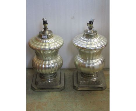 A pair of outsized contemporary hollow cast light metal urn shaped table lamps with stepped bases and moulded detail