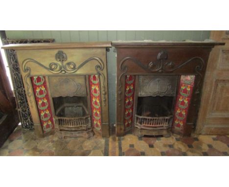A pair of good quality Art Nouveau style cast metal fire inserts with raised scrolling pomegranate detail and tube line ceram