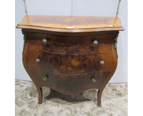 A reproduction bombe commode of three long graduated drawers with inlaid floral marquetry detail, 78 cm wide x 40 cm deep x 7