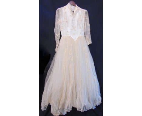 Vintage wedding dress, c1950s, with decorative netting over ivory satin, high neck with fitted bodice and head wear, 68cm wai