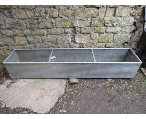 A large contemporary galvanised trough of rectangular form with rung divisions, 8ft long approximately 
